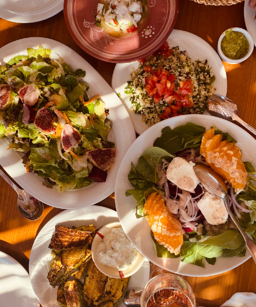 A wooden table topped with plates of food