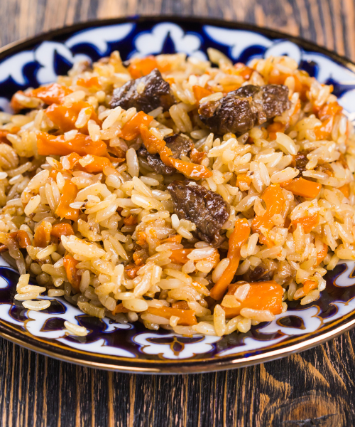 A plate of rice with meat and carrots