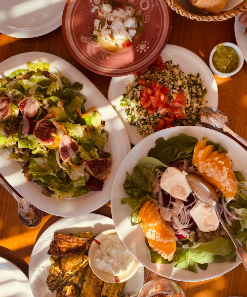 A wooden table topped with plates of food