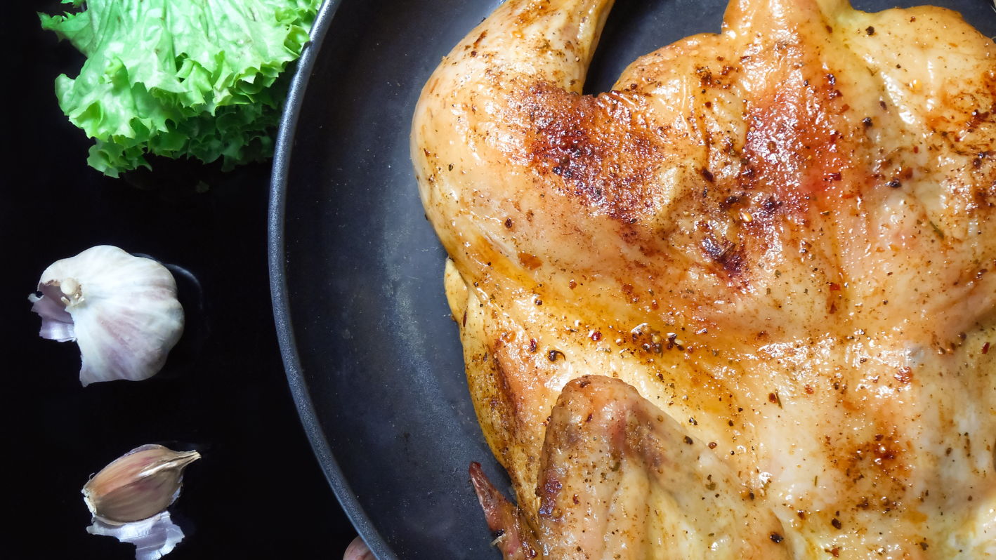 A close up of a chicken in a pan on a table